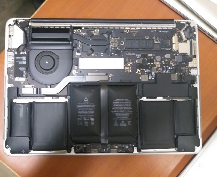 MacBook Pro opened showing logic board, cooling fan and battery cells — MacBook Pro repair in Vaishali by Solutionhubtech